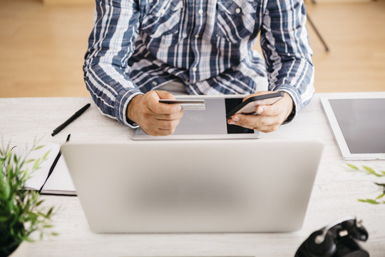 Man using credit card for paying her online order, partial view