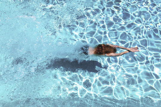 Woman diving underwater in swimming pool