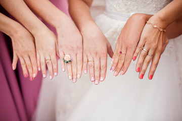 The bride and bridesmaids are showing their hands with rings