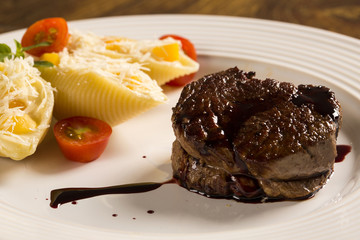 Baked conchiglioni with cottage cheese and beef steak served in