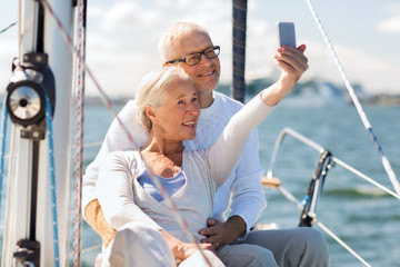Fototapeta na wymiar senior couple taking selfie on sail boat or yacht