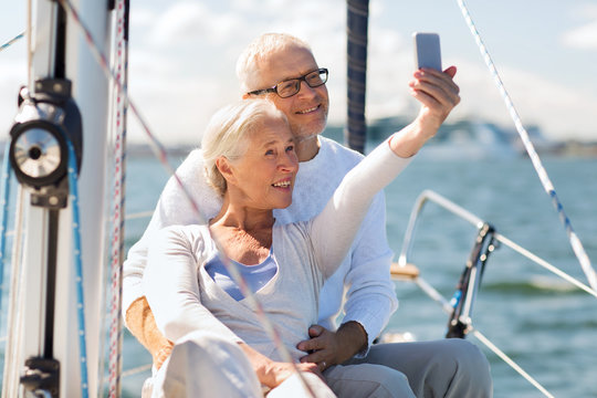 senior couple taking selfie on sail boat or yacht
