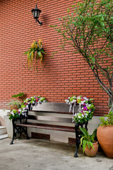 wooden bench against a brick wall building