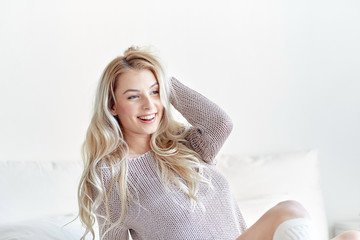 happy young woman stretching in bed at home