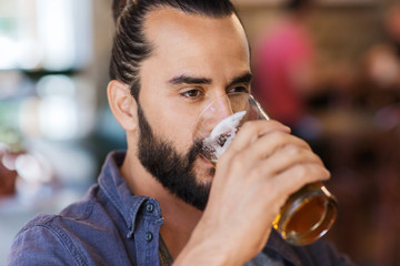 Fototapeta na wymiar happy man drinking beer at bar or pub