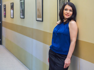 Beautiful Russian girl posing in office hall against the wall