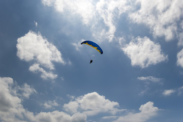 Paraglider in blue cloudy sky