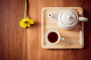Tea cups with teapot on old wooden table.