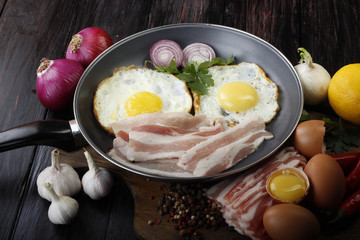 fried eggs with vegetables on wooden background