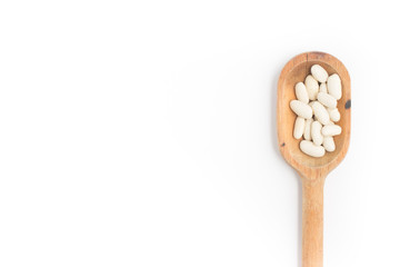 White beans into a spoon in white background. Phaseolus vulgaris