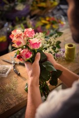 Male florist preparing flower bouquet