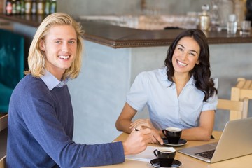 Business colleagues smiling while having a cup of tea