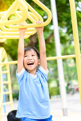 Obraz premium Boy play with hang yellow bar.