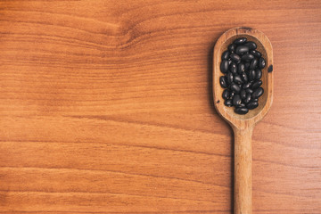 Black beans into a spoon. Phaseolus vulgaris 'Black turtle