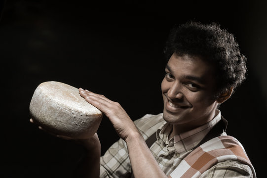 Handsome Cheesemaker Is Checking Cheeses In His Workshop Storage.