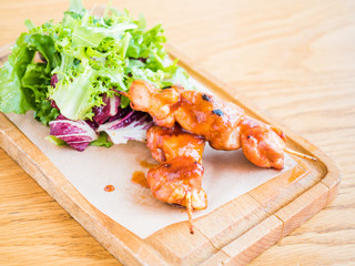 chicken with sauce on a skewer and vegetable