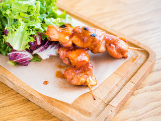 chicken with sauce on a skewer and vegetable