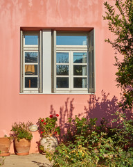 Fototapeta na wymiar colorful house window and yard with flowers and plants