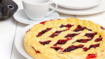 Homemade berry pie with cherries and raspberries on white wooden table