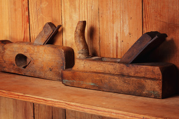 Two planes on the wooden shelf, on a wall from boards.