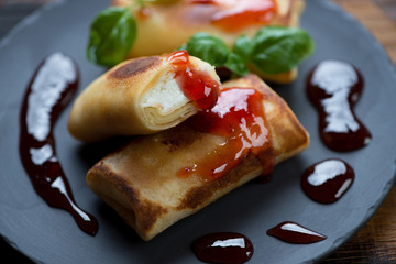 Closeup of rolled crepes with cottage cheese stuffing and jam