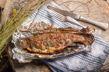 Obraz na płótnie Canvas Grilled whole trout on an aluminium foil