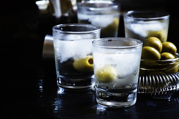 Cocktail with vodka, dry vermouth and green olives in the misted