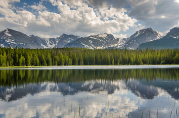 Fototapeta na wymiar Landscape of mountains and forest reflected in a lake.