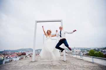Elegant wedding couple on the roof with high-tech architecture line