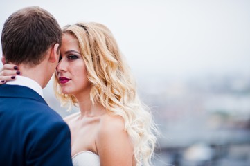 Close up portrait of charming blonde bride with groom