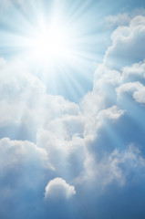 Bright sun shines among the white clouds