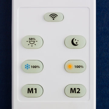 White remote control with the buttons on the blue background