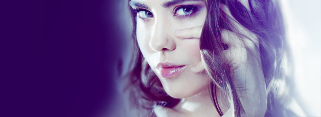 Beautiful young brunette girl with long wavy hair. Curly hairstyle. Effect of toning