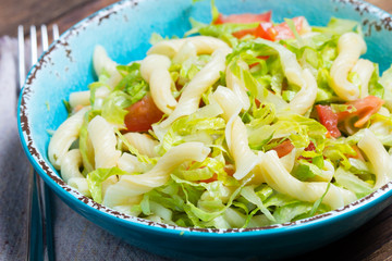 Italian food. Vegetables salad with pasta in blue bowl