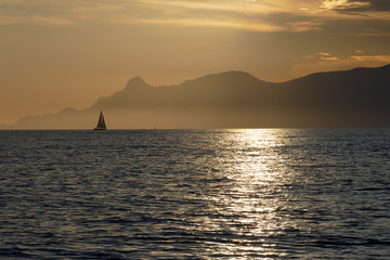 Naklejka na ściany i meble sunset landscape with sailing yacht