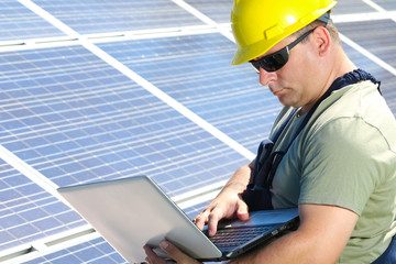 Green energy, solar panel and worker with laptop