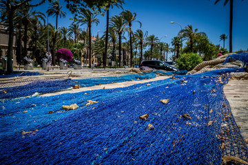 bright blue fish nets drying on stone path