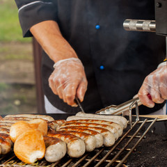 Hands man, cooking sausages on the hot grill