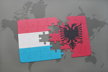 puzzle with the national flag of luxembourg and albania on a world map background.