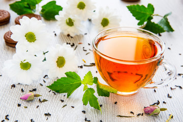 Beautiful cup of black tea with daisies