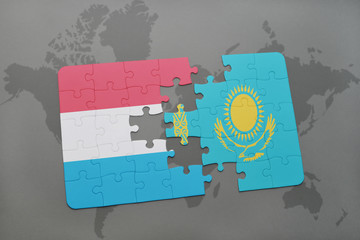 puzzle with the national flag of luxembourg and kazakhstan on a world map background.