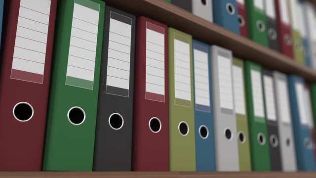 Rows of multicolored binders on shelves dolly close up shot. 4K seamless loopable clip