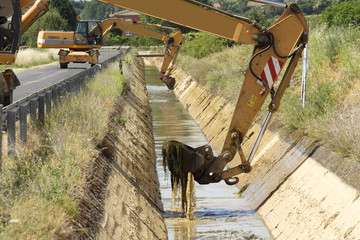 excavators to cleaning the water canals for traditional  irrigation in  crop fields , Leon, Spain ; selective focus