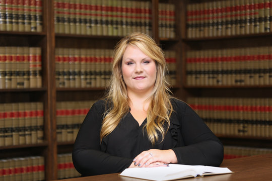 Young attractive female professional, woman lawyer in law library