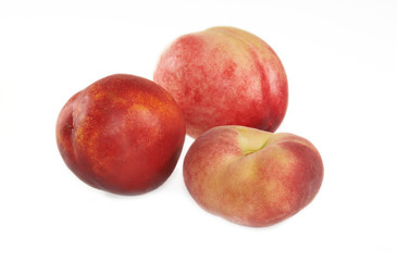 Fototapeta na wymiar Three nectarines and flat peach on white background.