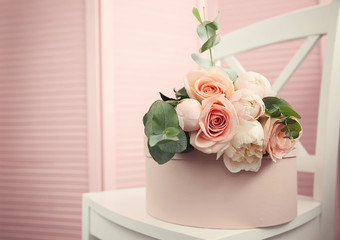 Beautiful bouquet of flowers on pink gift box