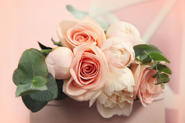 Beautiful bouquet of flowers on pink gift box, closeup