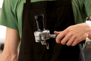 Barista holding portafilter with tamper in hand