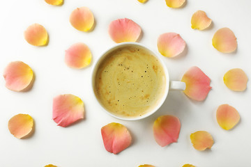 Pink rose petals with cup of coffee on white background