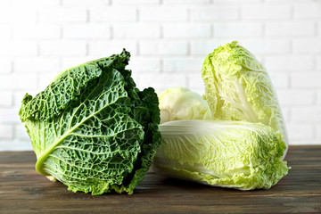 Different kinds of fresh cabbage on brick wall background
